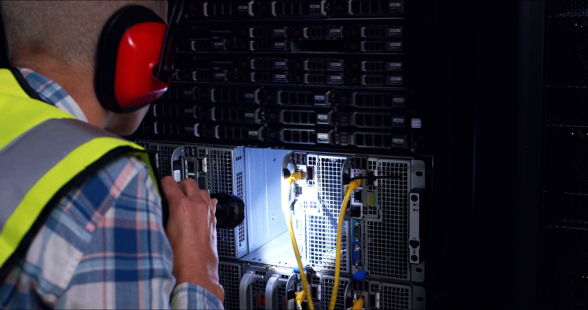 Technician, server room and cables inspection for system maintenance, hardware or backup power at night. Man with noise cancellation headphones for engineering, solution and data center electricity